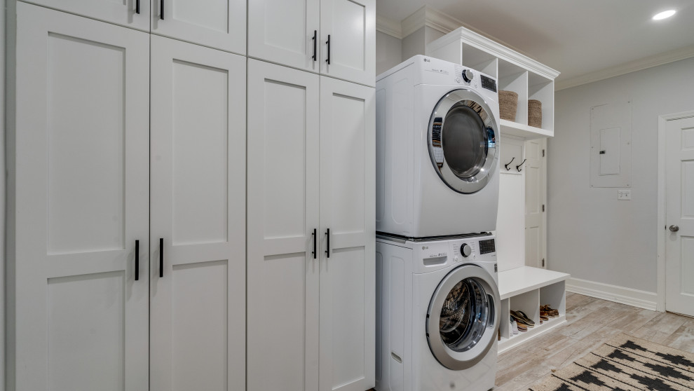 Large transitional dedicated laundry room in Other with recessed-panel cabinets, grey cabinets and beige floor.