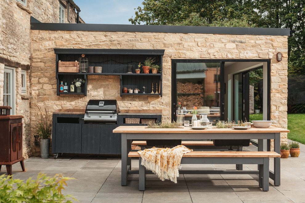 Inspiration for a large farmhouse back patio in Gloucestershire with natural stone paving and a bbq area.