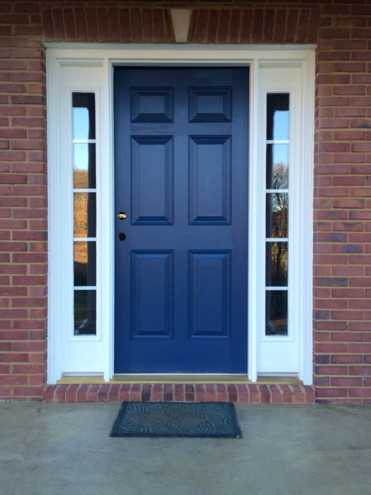 This is an example of a contemporary front door in Nashville with red walls and a blue front door.