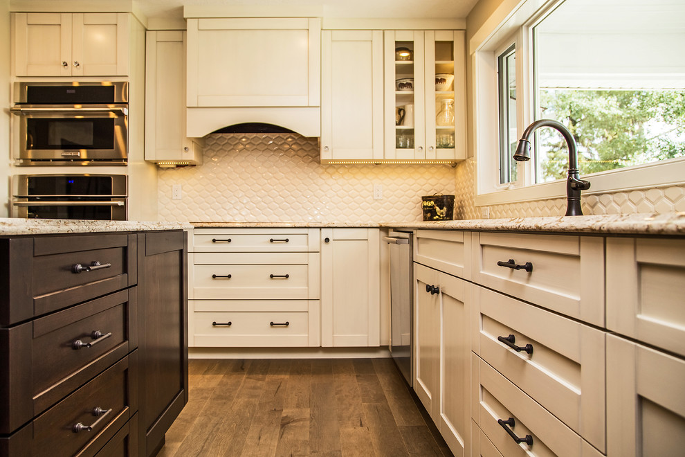 Example of a transitional medium tone wood floor kitchen design in Calgary with an undermount sink, shaker cabinets, white cabinets, quartz countertops, white backsplash, porcelain backsplash and stainless steel appliances