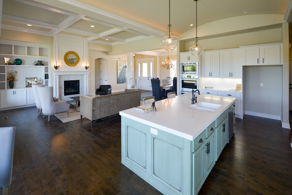 Inspiration for a mid-sized contemporary l-shaped eat-in kitchen in Wichita with an undermount sink, white cabinets, granite benchtops, white splashback, ceramic splashback, stainless steel appliances, dark hardwood floors and with island.