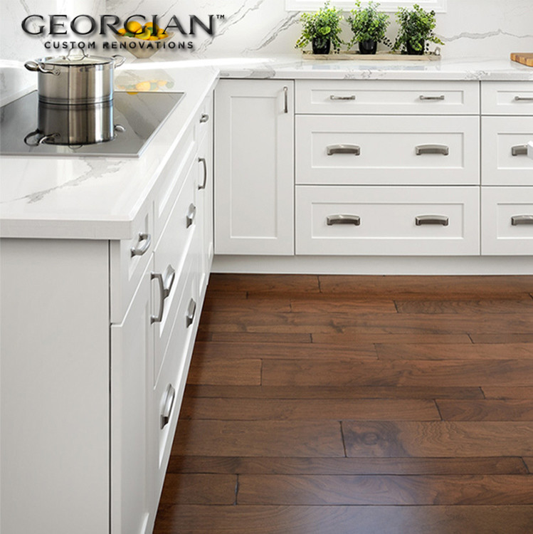 Inspiration for a small transitional l-shaped medium tone wood floor kitchen remodel with an undermount sink, shaker cabinets, white cabinets, quartzite countertops, white backsplash, stone slab backsplash, stainless steel appliances and an island