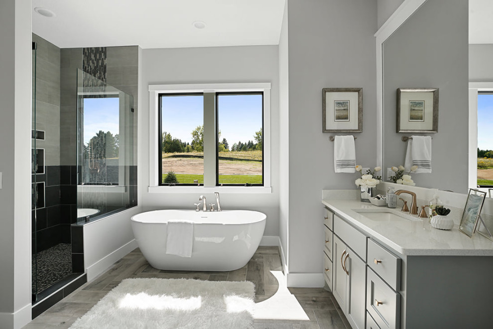 Inspiration for a transitional master bathroom in Minneapolis with shaker cabinets, grey cabinets, a freestanding tub, a shower/bathtub combo, a one-piece toilet, ceramic tile, grey walls, ceramic floors, an undermount sink, quartzite benchtops, grey floor, an open shower, white benchtops, a niche, a single vanity and a built-in vanity.