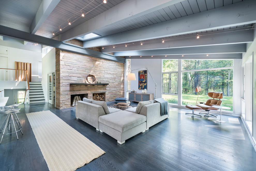 Large midcentury formal open concept living room in Boston with white walls, dark hardwood floors, a standard fireplace, a stone fireplace surround, no tv and grey floor.