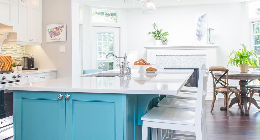 Eat-in kitchen - mid-sized transitional single-wall medium tone wood floor and brown floor eat-in kitchen idea in Toronto with an undermount sink, shaker cabinets, green cabinets, quartzite countertops, white backsplash, glass tile backsplash, stainless steel appliances, an island and white countertops