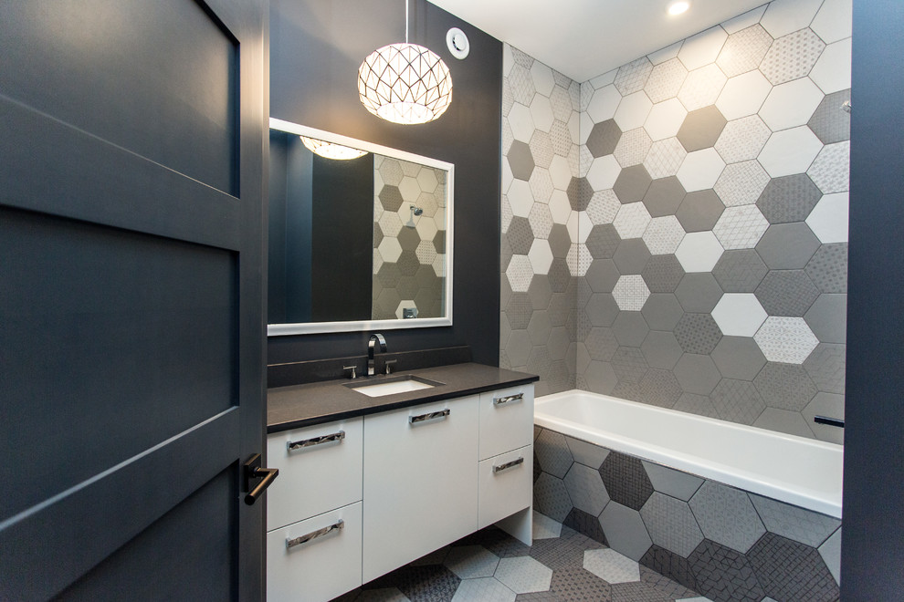 Photo of a mid-sized contemporary 3/4 bathroom in Other with flat-panel cabinets, white cabinets, an alcove tub, a shower/bathtub combo, gray tile, white tile, ceramic tile, black walls, ceramic floors, an undermount sink, soapstone benchtops, multi-coloured floor and a shower curtain.