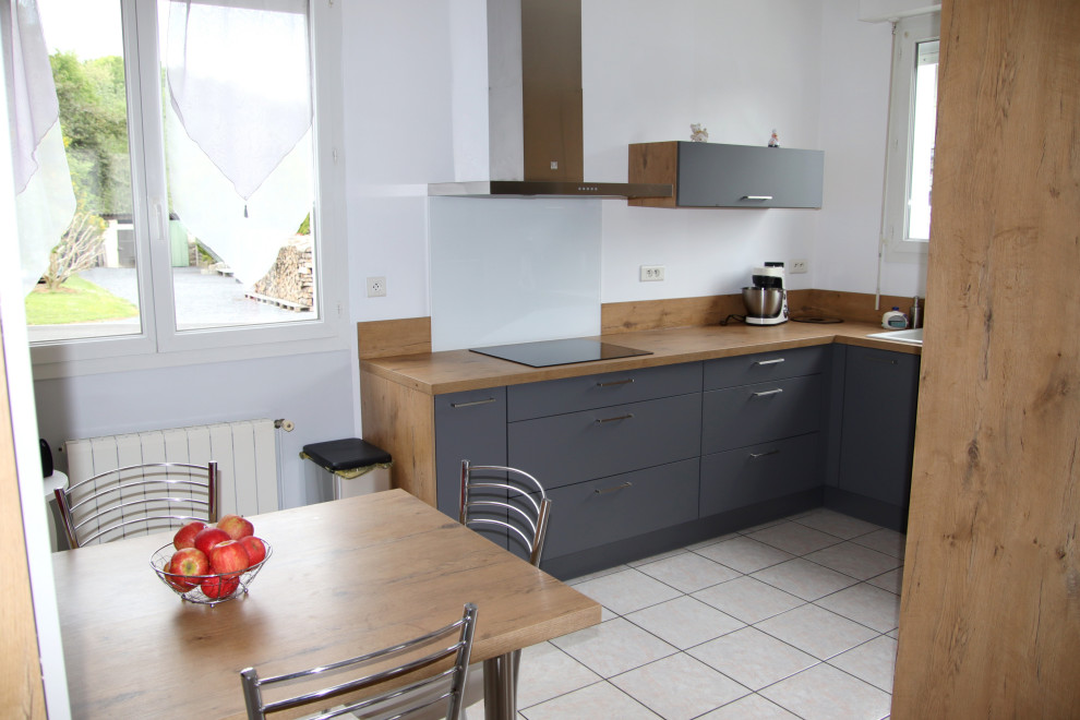 Cette image montre une cuisine ouverte noire et bois design en U de taille moyenne avec un plan de travail en stratifié.