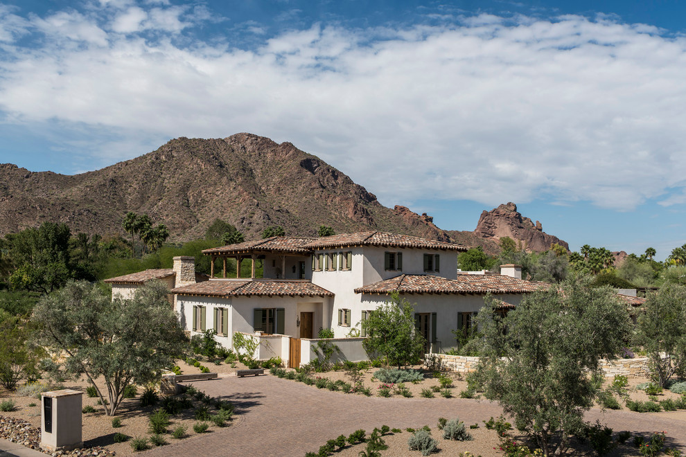 Inspiration for an expansive country two-storey stucco beige exterior in Phoenix with a gable roof.