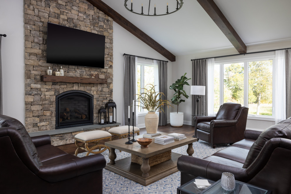 Inspiration for a mid-sized transitional enclosed living room in DC Metro with beige walls, a standard fireplace, a stone fireplace surround, a wall-mounted tv, brown floor, exposed beam, vaulted and dark hardwood floors.