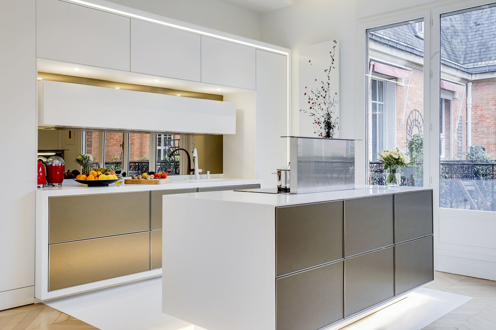 Inspiration for a contemporary kitchen in Paris with flat-panel cabinets, white cabinets, mirror splashback, with island and white floor.