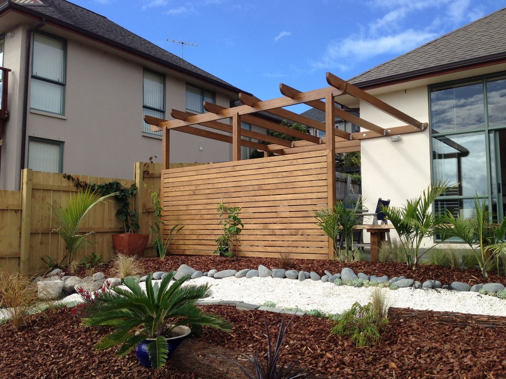 This is an example of a small mediterranean front yard verandah in Auckland with a vertical garden, decking and a pergola.