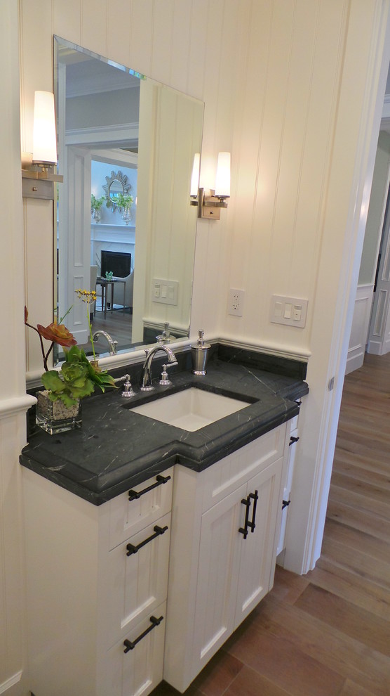 Inspiration for a small traditional 3/4 bathroom in Los Angeles with an undermount sink, beaded inset cabinets, white cabinets, soapstone benchtops, white walls and medium hardwood floors.