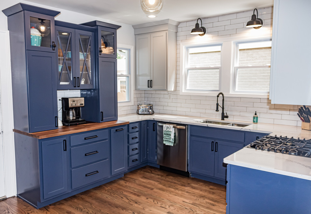 Inspiration for a small transitional u-shaped medium tone wood floor and brown floor eat-in kitchen remodel in St Louis with an undermount sink, shaker cabinets, blue cabinets, quartz countertops, white backsplash, subway tile backsplash, stainless steel appliances and white countertops
