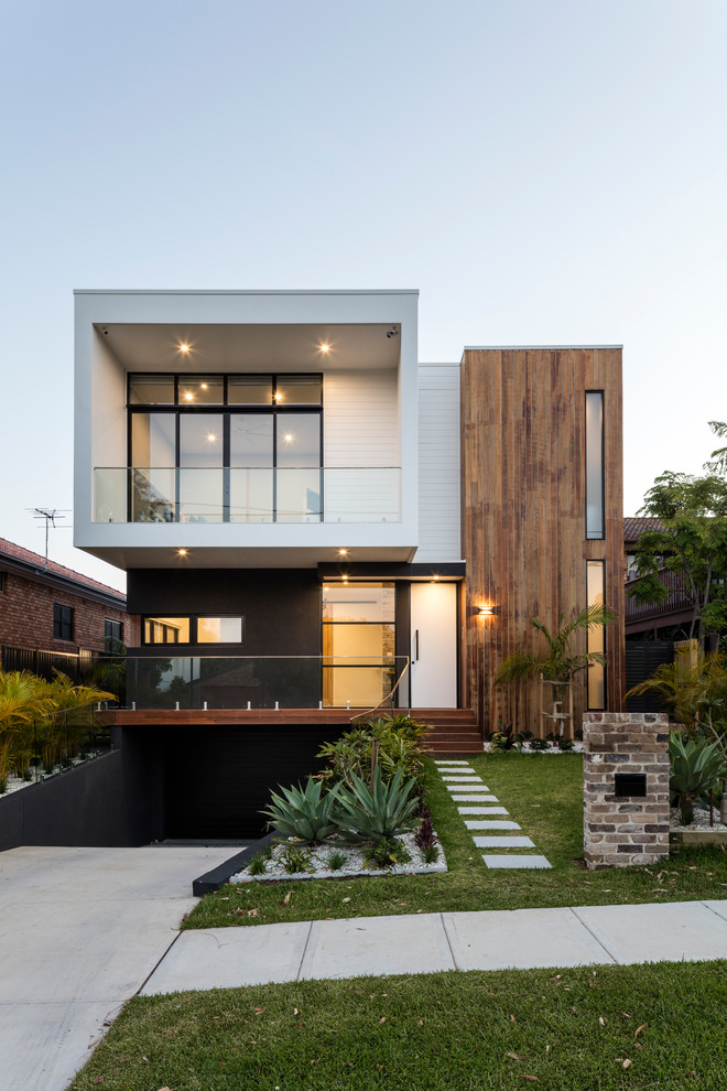 This is an example of a contemporary two-storey white house exterior in Sydney with mixed siding and a flat roof.