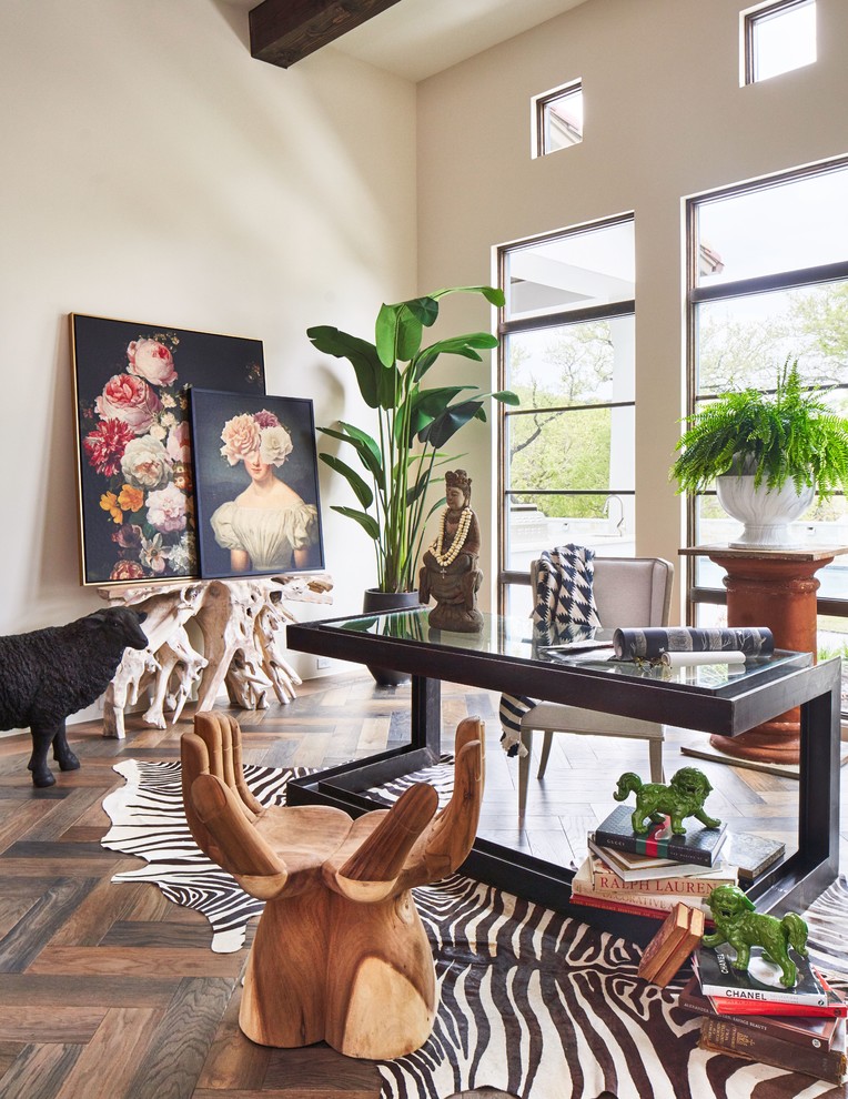 This is an example of a mediterranean home office in Austin with beige walls, dark hardwood floors, a freestanding desk and brown floor.