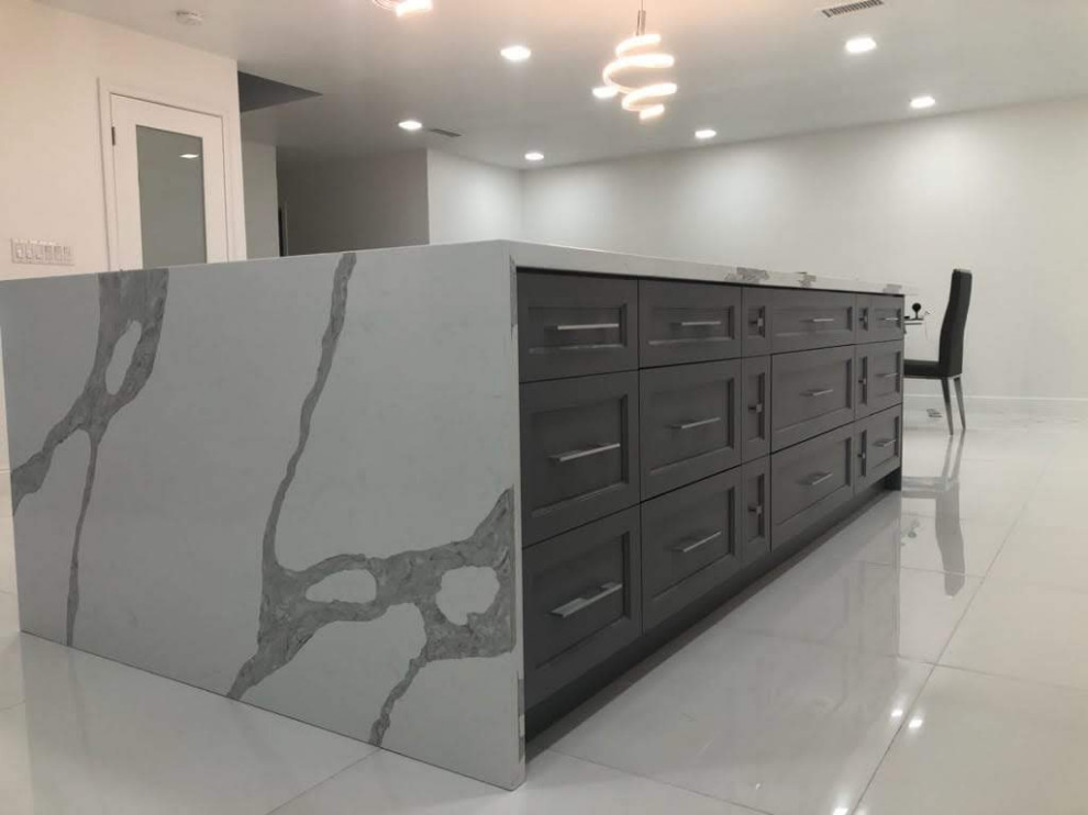 Example of a transitional single-wall porcelain tile and white floor eat-in kitchen design in Miami with an undermount sink, shaker cabinets, white cabinets, quartz countertops, white backsplash, mosaic tile backsplash, stainless steel appliances and an island