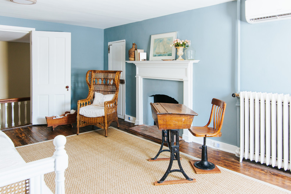 Inspiration pour une grande chambre parentale traditionnelle avec un mur bleu, un sol en bois brun, une cheminée standard, un manteau de cheminée en plâtre, un sol marron et poutres apparentes.