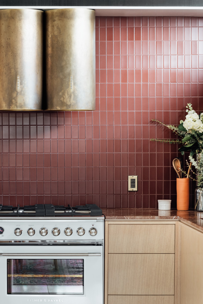 Inspiration för mellanstora 50 tals rött kök, med en integrerad diskho, släta luckor, skåp i ljust trä, marmorbänkskiva, rött stänkskydd, stänkskydd i glaskakel, vita vitvaror, terrazzogolv, en halv köksö och grått golv