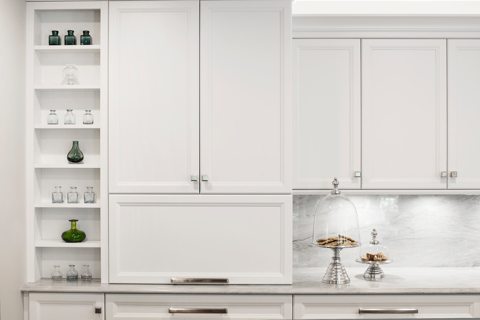 Inspiration for a large transitional single-wall medium tone wood floor and brown floor kitchen remodel in Denver with an undermount sink, recessed-panel cabinets, white cabinets, white backsplash, stone slab backsplash, stainless steel appliances and an island