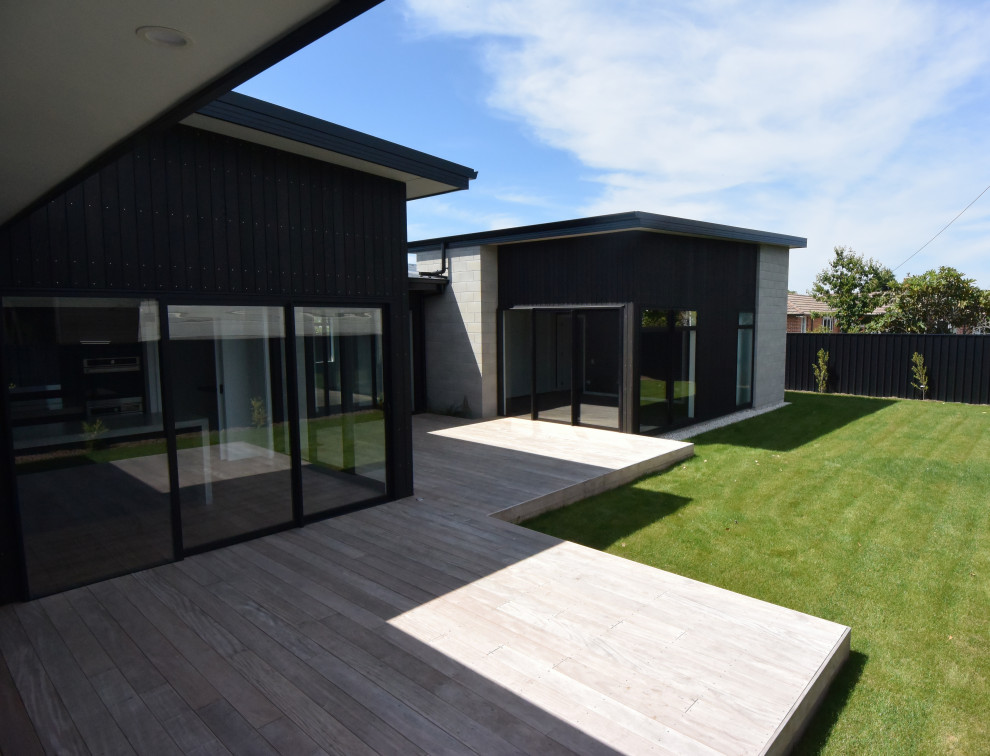 Inspiration for a modern concrete black exterior with a black roof.