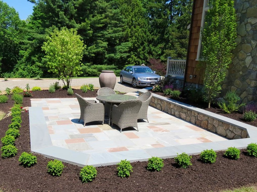 Mid-sized mediterranean side yard patio in New York with natural stone pavers and no cover.