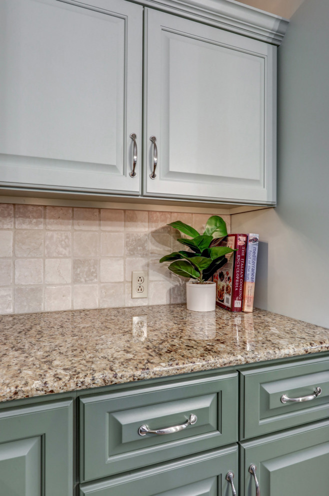 Eat-in kitchen - mid-sized transitional l-shaped ceramic tile and beige floor eat-in kitchen idea with a double-bowl sink, raised-panel cabinets, green cabinets, granite countertops, beige backsplash, ceramic backsplash, stainless steel appliances, an island and beige countertops