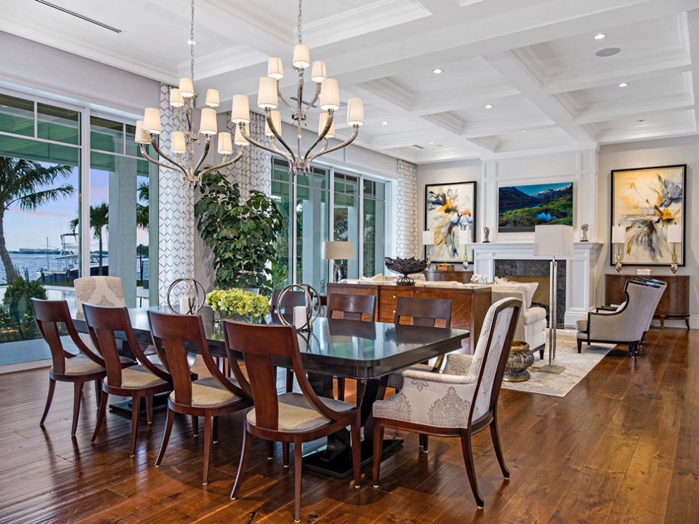 Transitional medium tone wood floor dining room photo in Miami with white walls and a standard fireplace