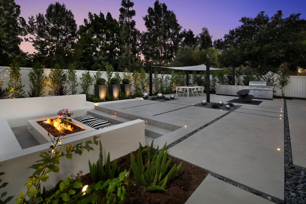 Inspiration for a large modern backyard patio in Orange County with a fire feature, concrete slab and a gazebo/cabana.
