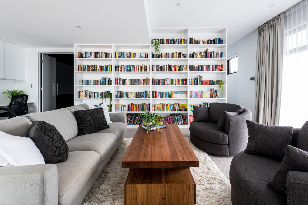 Foto di un grande soggiorno minimal aperto con libreria, pareti bianche, moquette, nessuna TV e pavimento beige