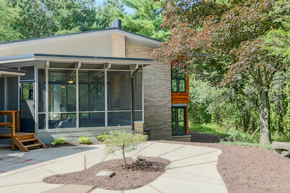 This is an example of a midcentury split-level grey exterior in Grand Rapids with mixed siding.