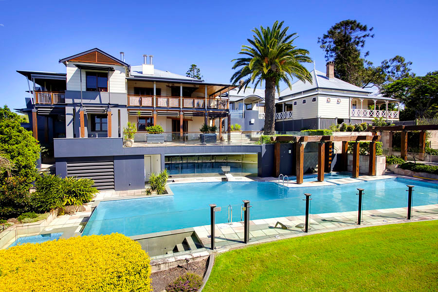 This is an example of an expansive transitional backyard custom-shaped pool in Brisbane.