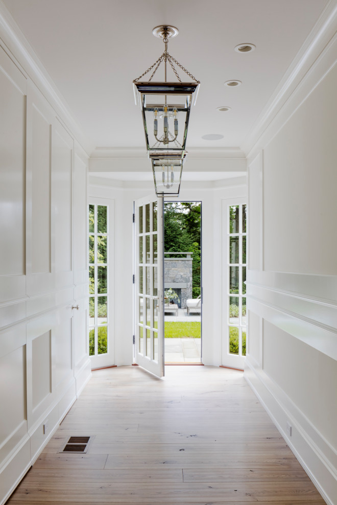 Idée de décoration pour un couloir tradition de taille moyenne avec un mur blanc et parquet clair.