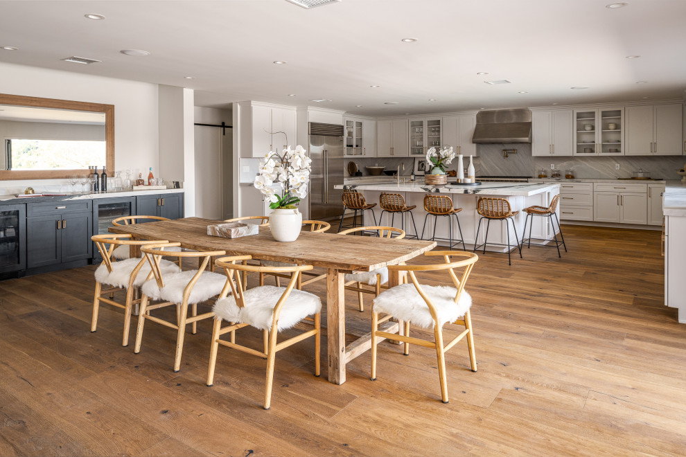 Esempio di una sala da pranzo aperta verso la cucina classica con pareti bianche, pavimento in legno massello medio e pavimento marrone