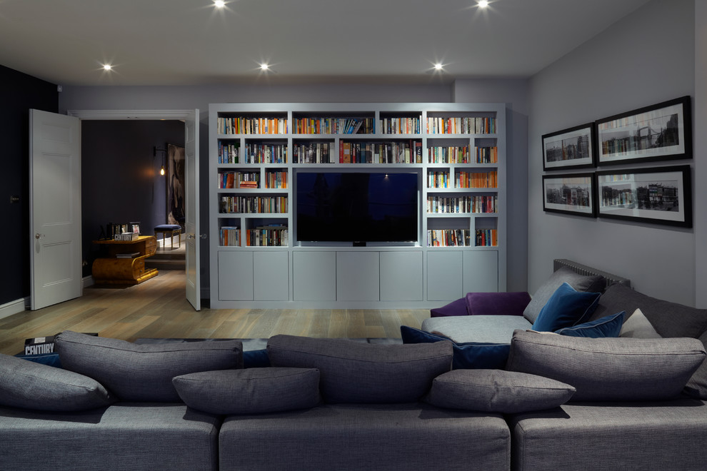 Mid-sized contemporary fully buried basement in London with purple walls, medium hardwood floors and no fireplace.