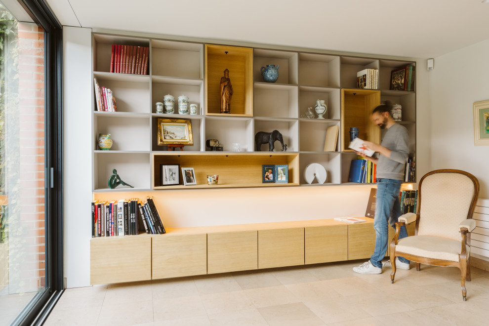 Photo of a large contemporary gender-neutral storage and wardrobe in Lille with beaded inset cabinets, light wood cabinets, limestone floors and beige floor.