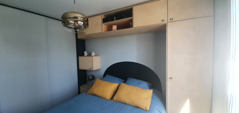 Kleines Modernes Schlafzimmer mit blauer Wandfarbe und hellem Holzboden in Paris