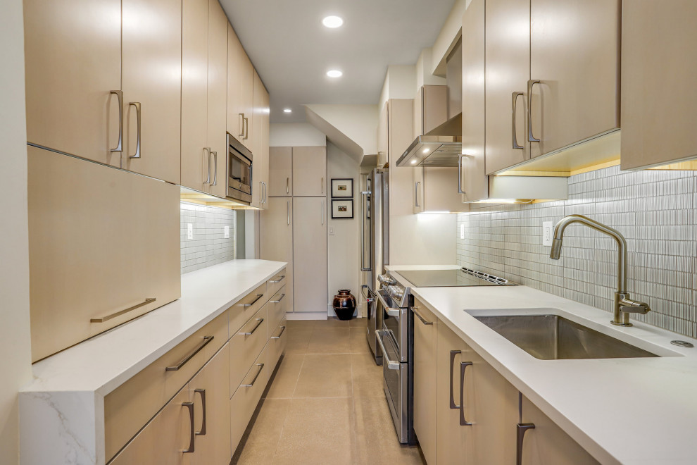Kitchen pantry - mid-sized transitional galley kitchen pantry idea in DC Metro with a drop-in sink, flat-panel cabinets, light wood cabinets, stainless steel appliances and no island