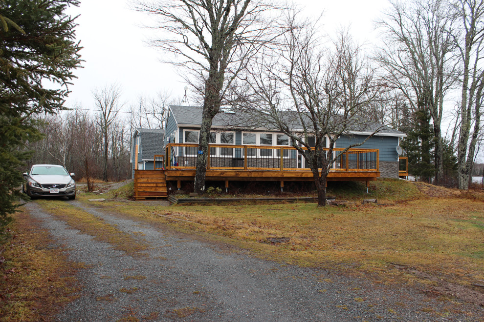 Kleines, Zweistöckiges Landhausstil Haus mit Vinylfassade, blauer Fassadenfarbe, Mansardendach, Schindeldach, grauem Dach und Verschalung in Sonstige