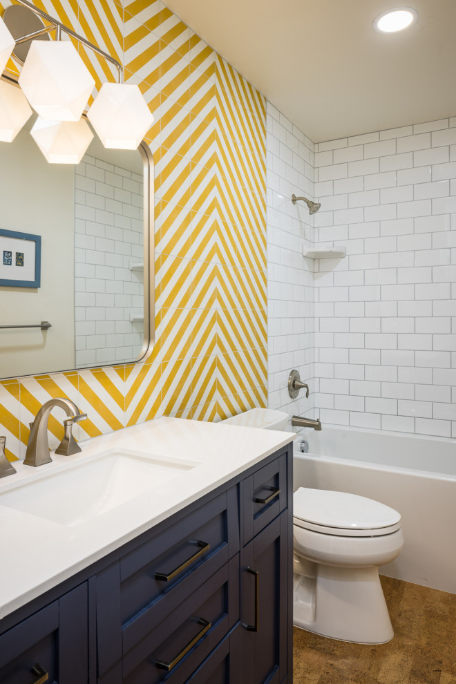 Design ideas for a mid-sized kids bathroom in Other with shaker cabinets, blue cabinets, an alcove tub, a shower/bathtub combo, a two-piece toilet, yellow tile, ceramic tile, white walls, cork floors, an undermount sink, a shower curtain, white benchtops, a single vanity and a freestanding vanity.