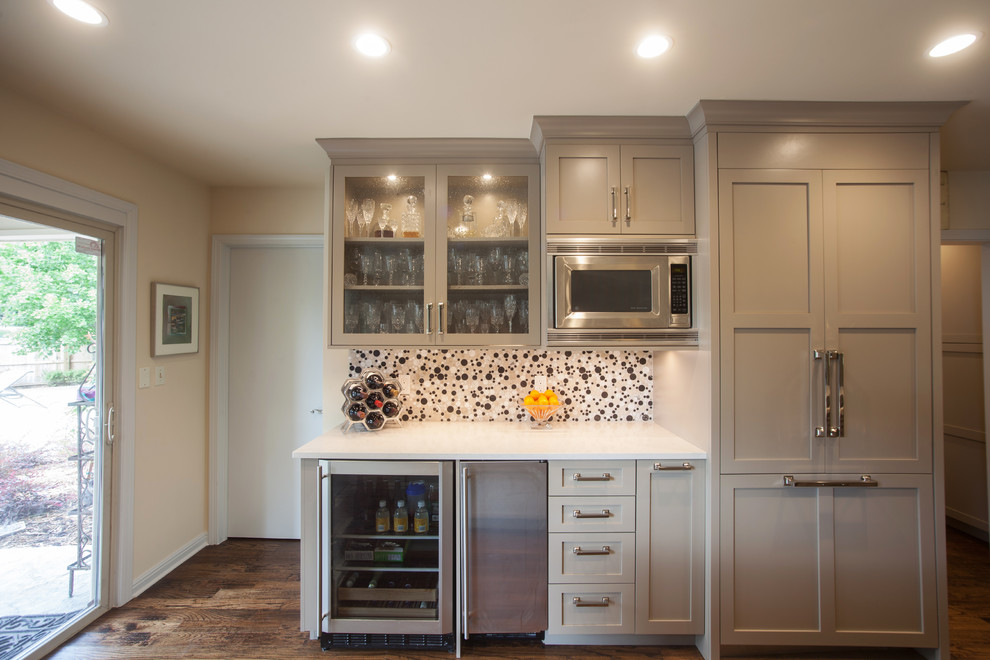 Inspiration for a large contemporary medium tone wood floor and brown floor open concept kitchen remodel with an undermount sink, shaker cabinets, beige cabinets, quartzite countertops, white backsplash, mosaic tile backsplash, stainless steel appliances and an island