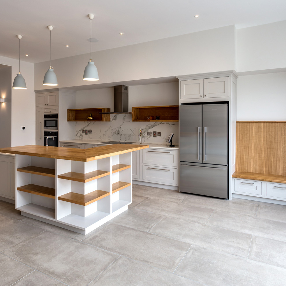 Foto på ett stort funkis kök med öppen planlösning, med vitt stänkskydd, stänkskydd i stenkakel, klinkergolv i porslin, en köksö och grått golv