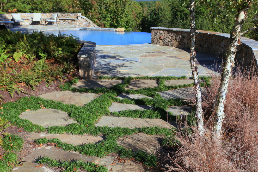 Pool - large rustic backyard stone and custom-shaped infinity pool idea
