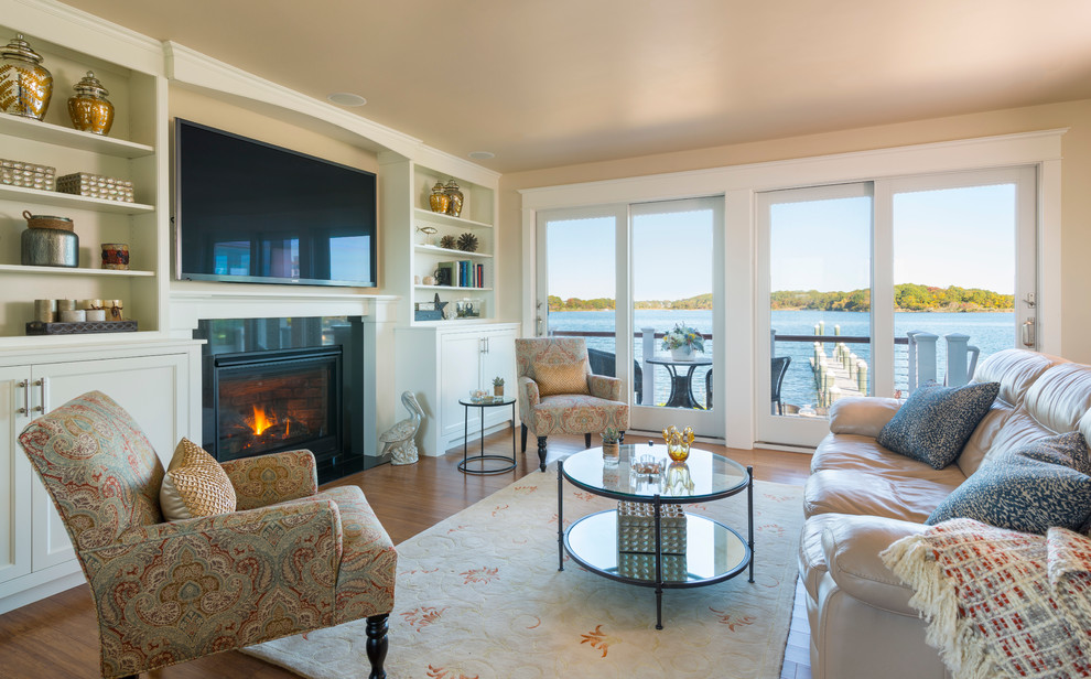 This is an example of a mid-sized beach style open concept living room in Providence with beige walls, dark hardwood floors, a standard fireplace, a stone fireplace surround and a built-in media wall.