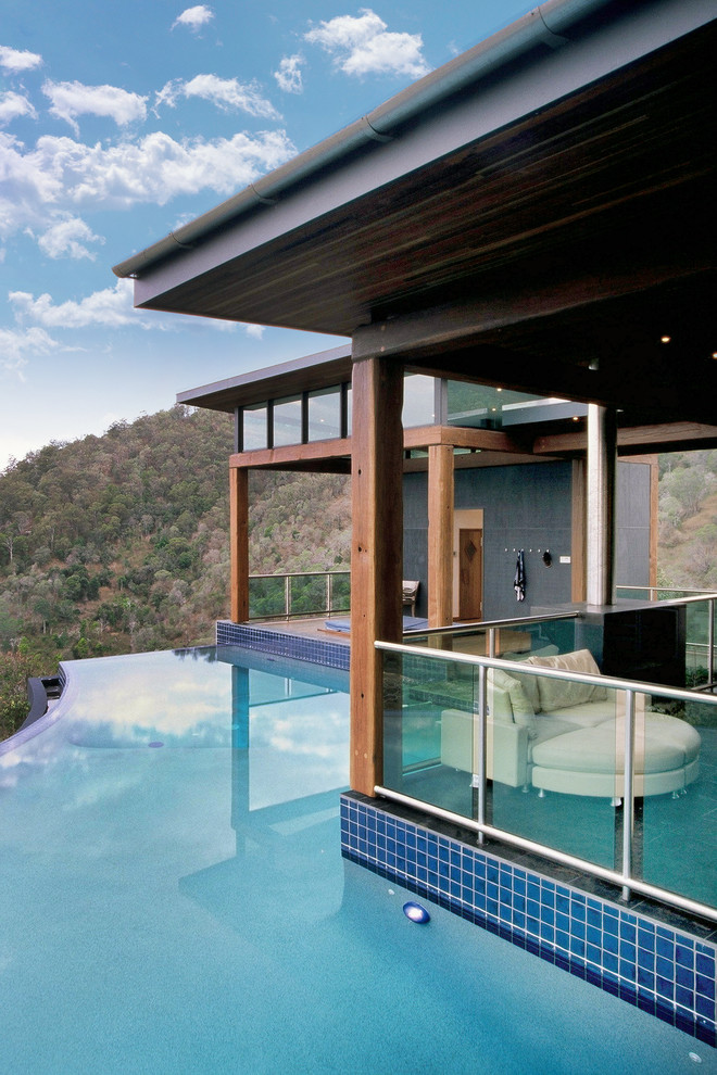 This is an example of an expansive modern backyard custom-shaped infinity pool in Brisbane.