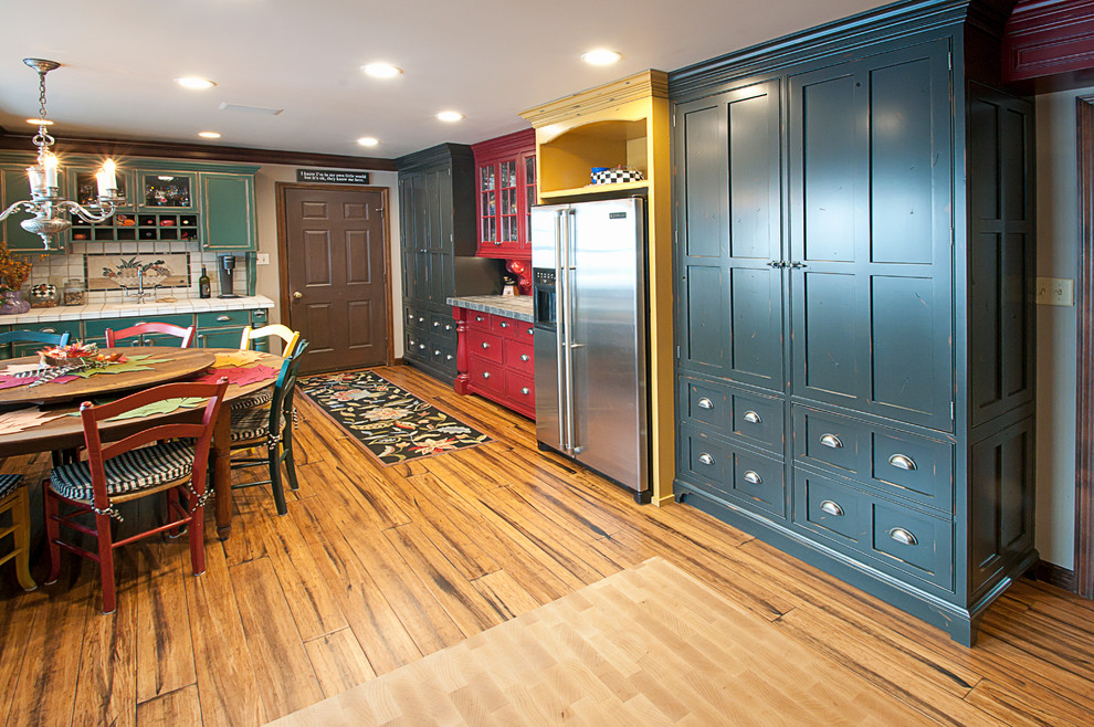 This is an example of a country eat-in kitchen in Other with a farmhouse sink, beaded inset cabinets, blue cabinets, marble benchtops and stainless steel appliances.
