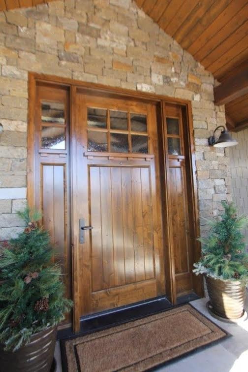 This is an example of a large arts and crafts front door in Denver with a single front door, a medium wood front door and concrete floors.