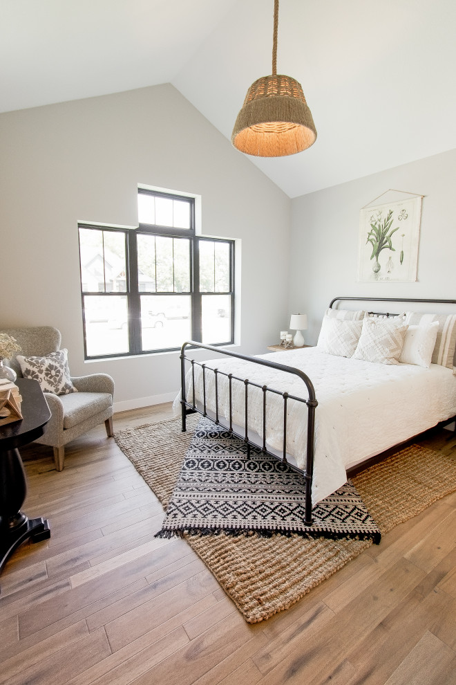 На фото: гостевая спальня (комната для гостей) в стиле неоклассика (современная классика) с белыми стенами, паркетным полом среднего тона и коричневым полом