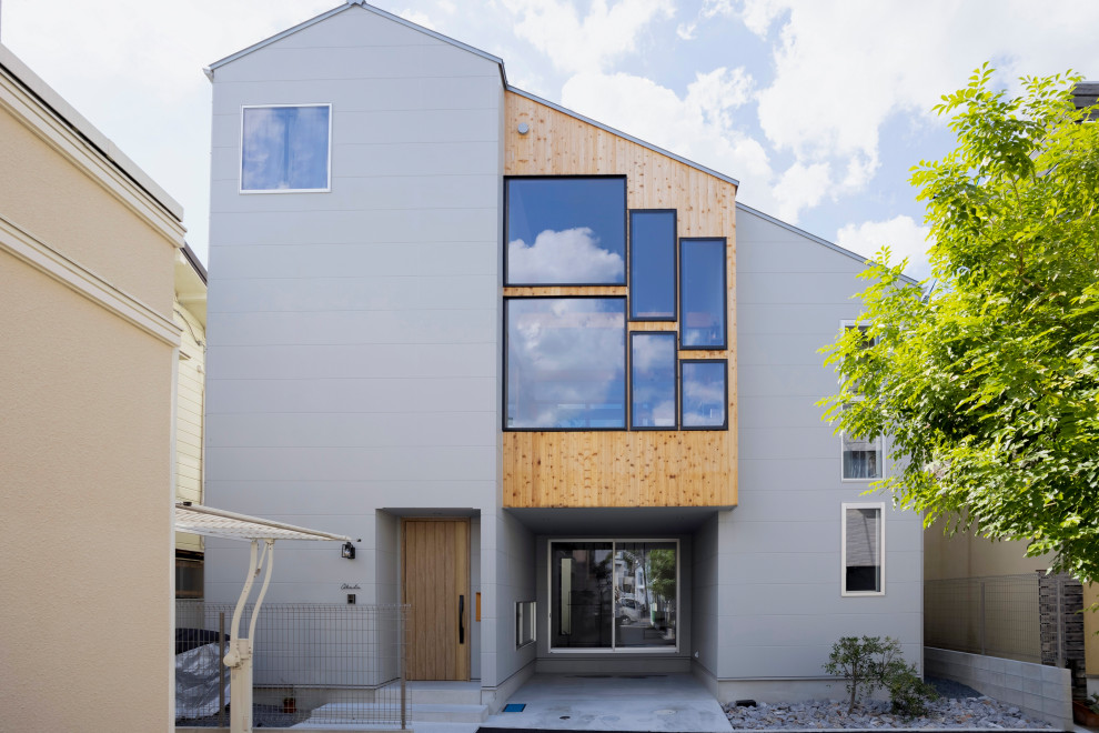 Kleines, Dreistöckiges Rustikales Einfamilienhaus mit Mix-Fassade, grauer Fassadenfarbe, Satteldach, Blechdach, grauem Dach und Schindeln in Sonstige
