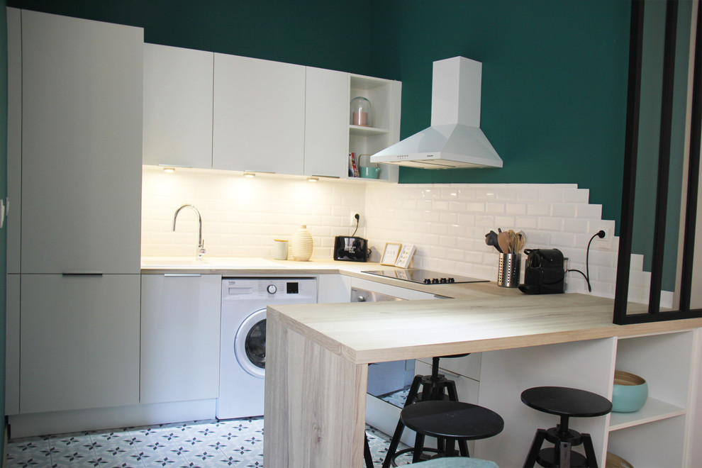 Inspiration for a mid-sized midcentury u-shaped open plan kitchen in Lyon with an undermount sink, beaded inset cabinets, white cabinets, wood benchtops, white splashback, ceramic splashback, white appliances, cement tiles, no island, blue floor and beige benchtop.