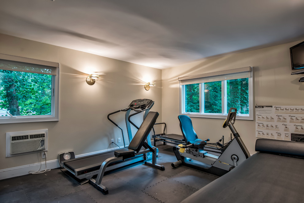 Photo of a modern home gym in New York with beige walls, carpet and black floor.